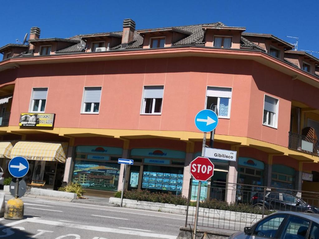 una señal de parada roja frente a un edificio en B&B MANITO, en Lavena Ponte Tresa
