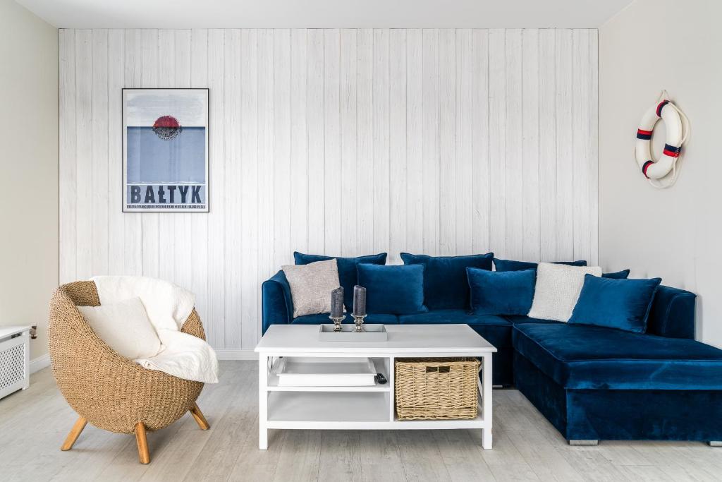 sala de estar con sofá azul y silla en Lion Apartments - Blue Marina Premium Apartment Okrzei 21, en Sopot