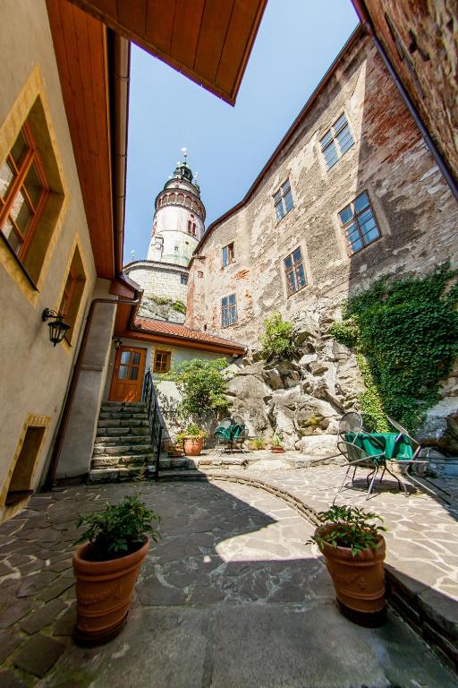 budynek z latarnią morską w tle z doniczkami w obiekcie Pension U Zámku w Czeskim Krumlovie