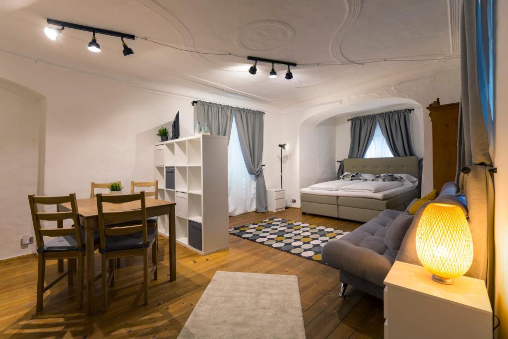 a living room with a table and a bed at Albergo Diffuso ELA Living - Apartment Bellepoque in Egna