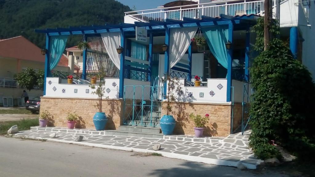 een blauw huis met potplanten ervoor bij Vangelis Studios in Skala Potamias