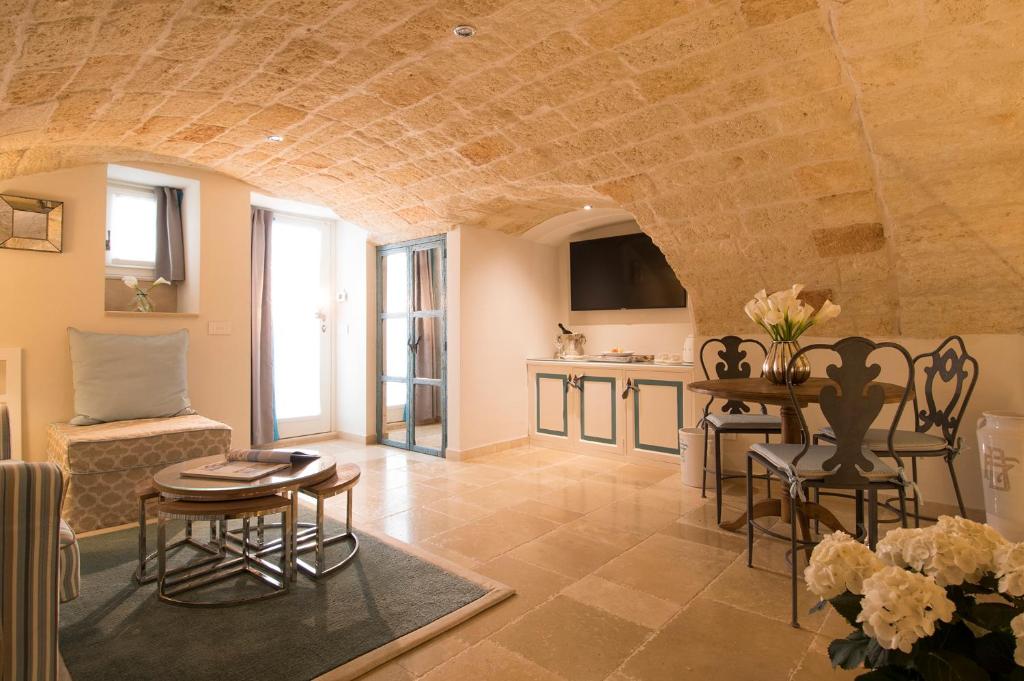 a living room with a table and chairs and a kitchen at Hotel Don Ferrante in Monopoli