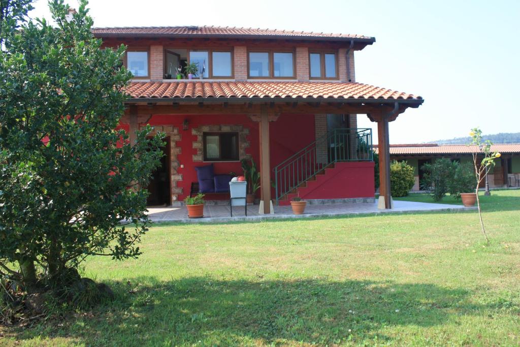 a red house with a red staircase in a yard at Llosa de Ibio in Ibio