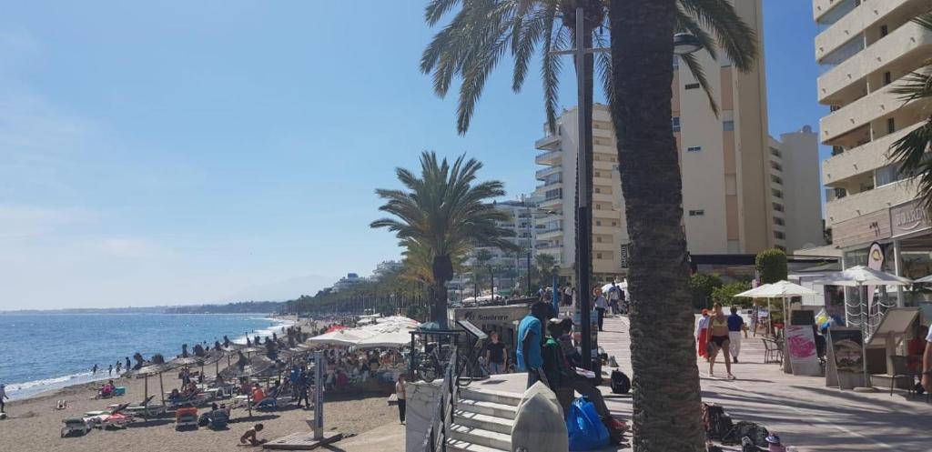 una playa con multitud de personas y el océano en Apartment Serna, en Marbella