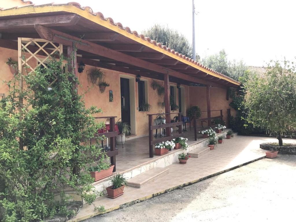 a porch of a house with potted plants on it at Domu de Palla- IUN-E5167 in Bauladu