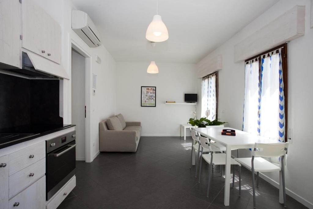 cocina y sala de estar con mesa y sillas en Residenza Jennifer, en Lido di Jesolo