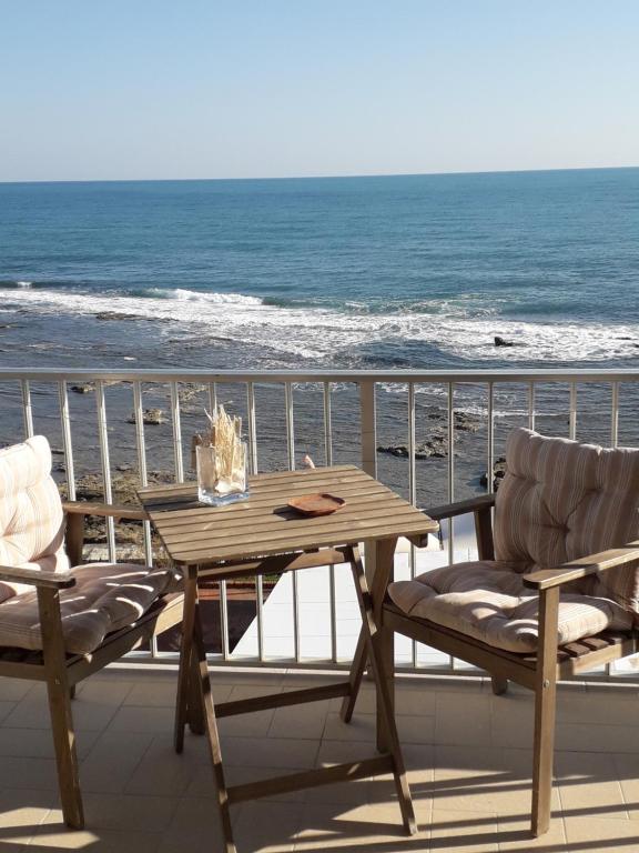 uma mesa de madeira e cadeiras numa varanda com o oceano em Casa Maritrì Locazione Turistica em Marzamemi