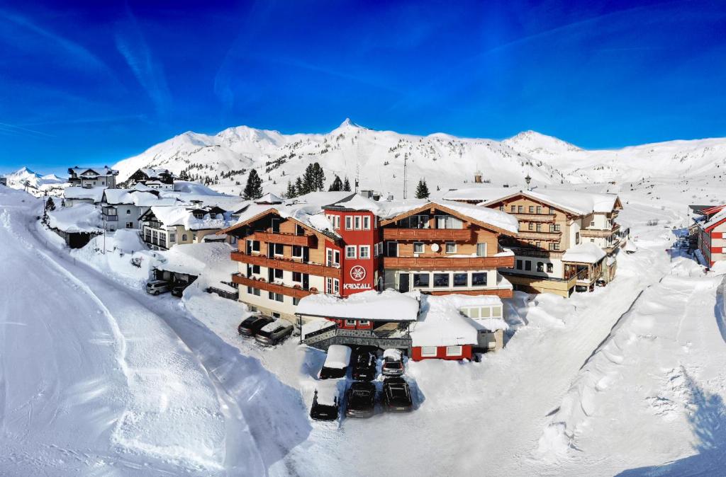 ein schneebedecktes Dorf mit Bergen im Hintergrund in der Unterkunft Hotel Kristall in Obertauern
