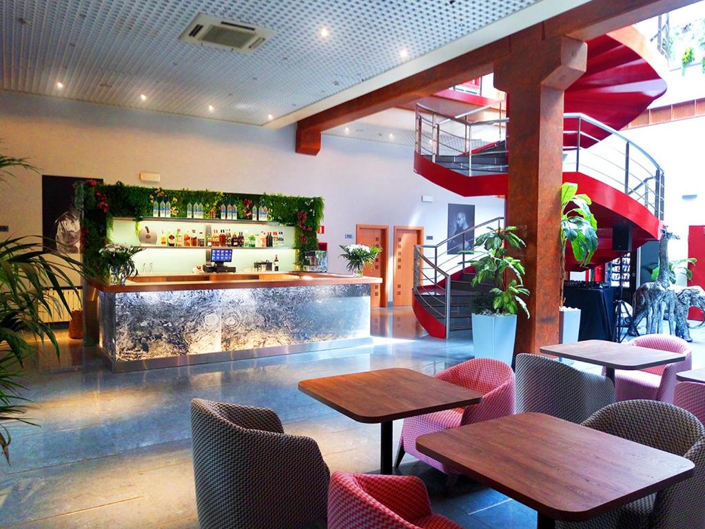 restauracja ze stołami i krzesłami oraz bar w obiekcie Hotel Fabrik w mieście Humanes de Madrid