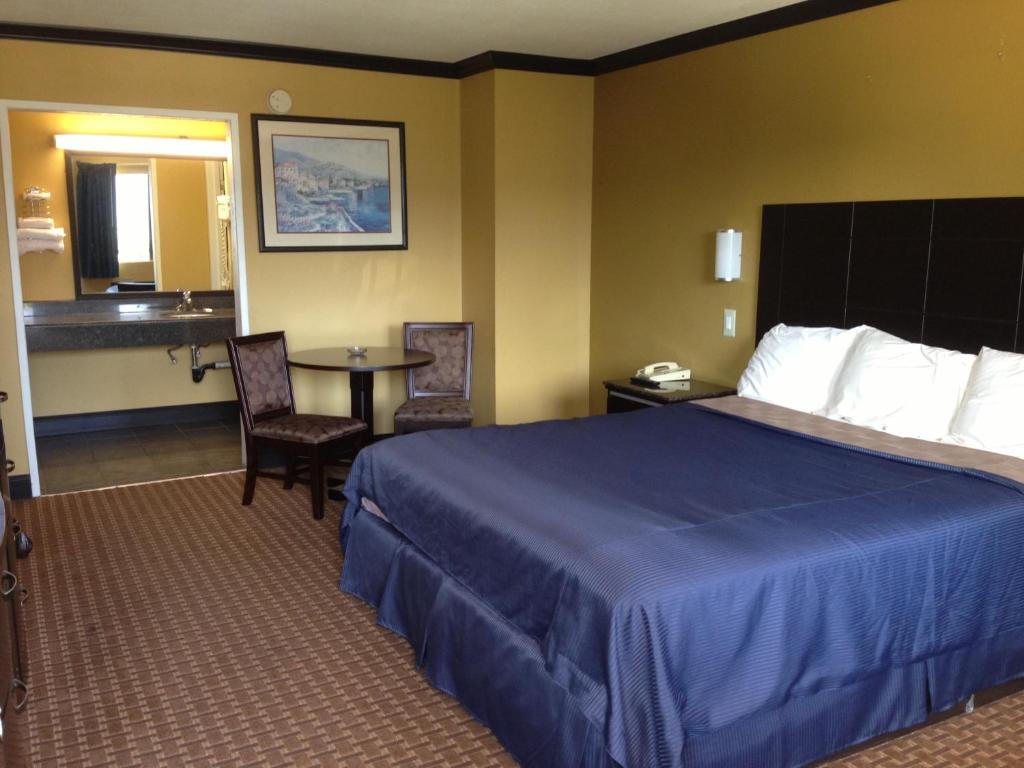 a hotel room with a bed and a table at Del Amo Inn in Torrance
