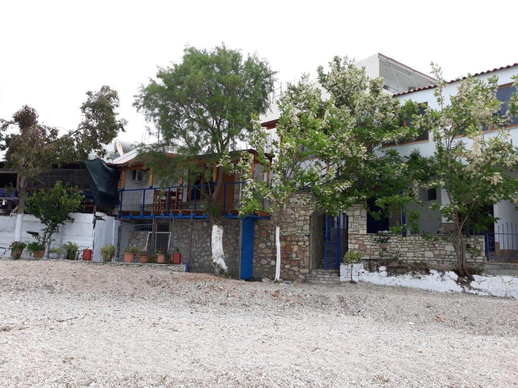 a house with a blue door and some trees at Beleris Rooms in Himare