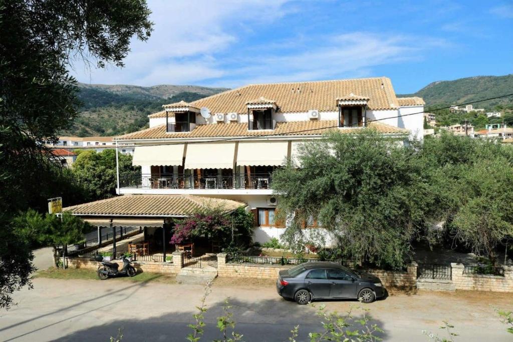 uma casa com um carro estacionado em frente em Hotel Akropolis em Sivota