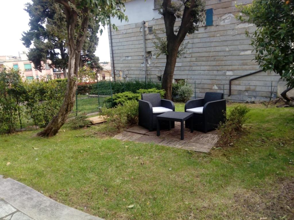 due sedie e un tavolo in un cortile di AL VILLINO DUSE a Genova