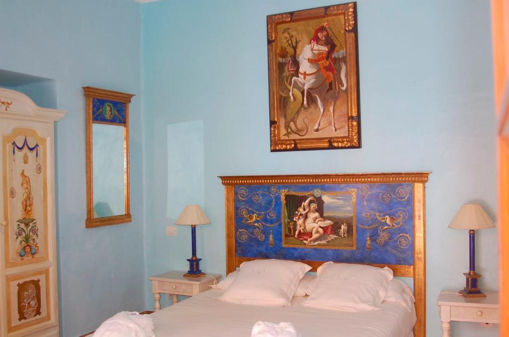 a bedroom with a bed with a painting on the wall at La Casona de Yaiza in Yaiza