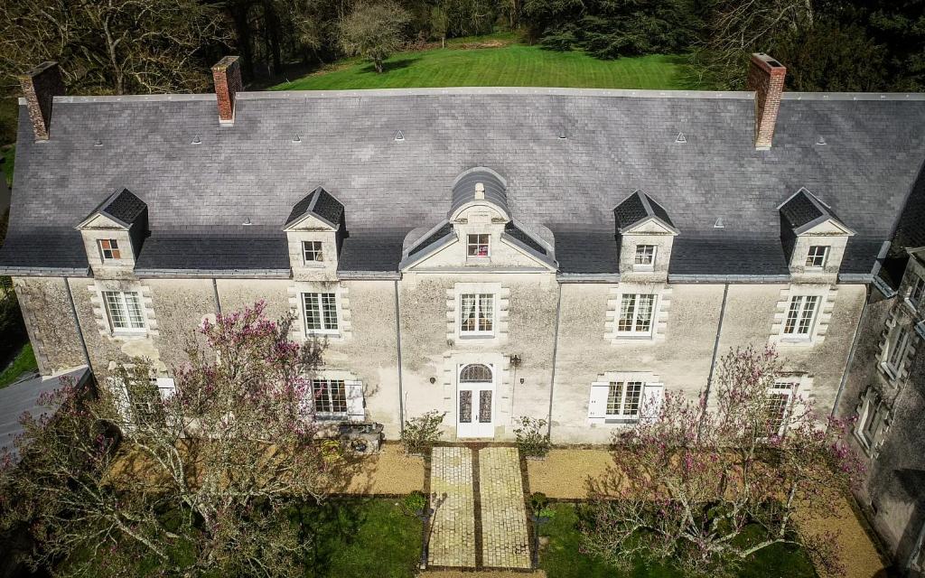 une vue aérienne sur une grande maison avec un toit dans l'établissement Château de la Grand'cour, à Grandchamp-des-Fontaines