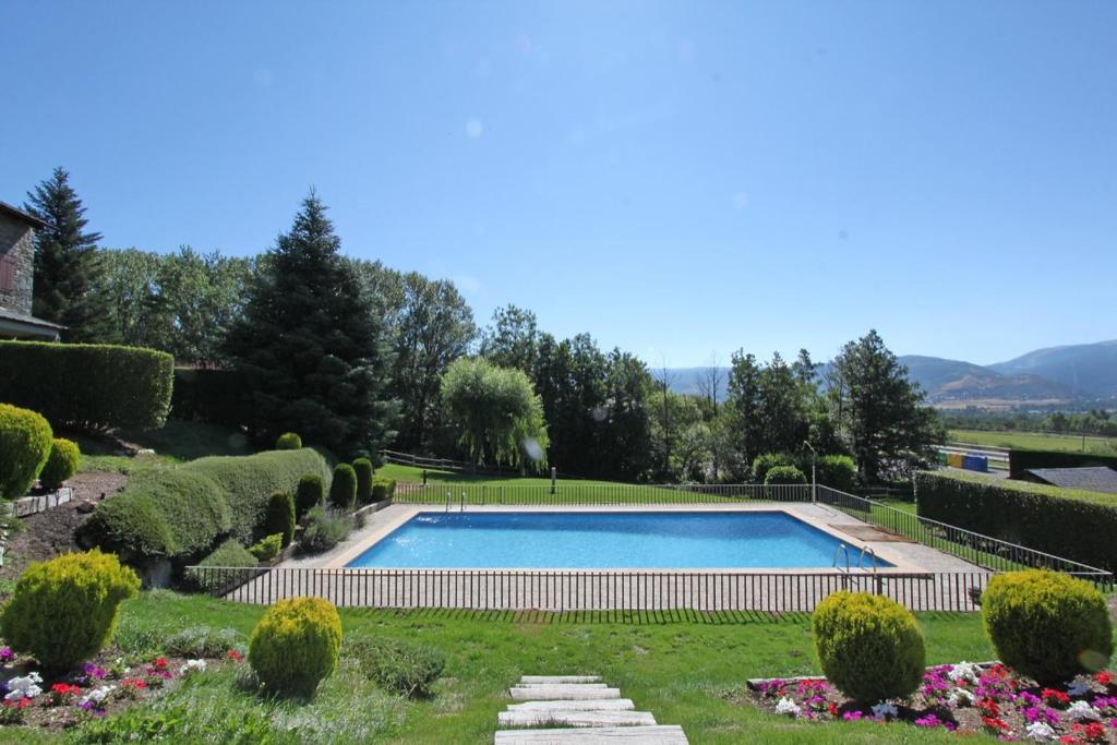 a swimming pool in the middle of a garden at Tpa Casa en Pleta de Saga con piscina para 6/8 personas in Ger
