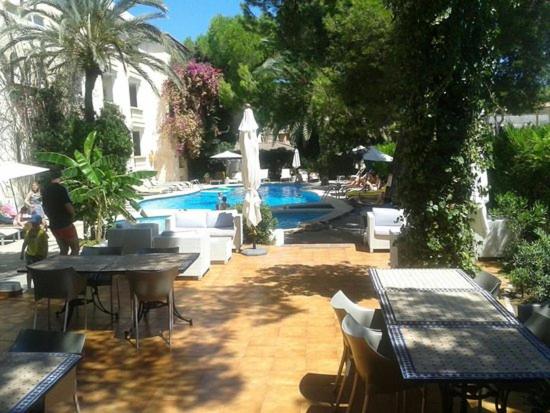 un patio con tavoli, sedie e piscina di EL ROJO 2 a Can Picafort