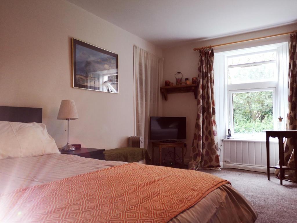 a bedroom with a bed and a window and a television at Rose cottage in Millport