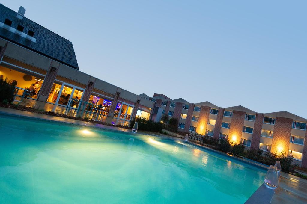 a large swimming pool in front of a building at Novotel Wavre Brussels East in Wavre