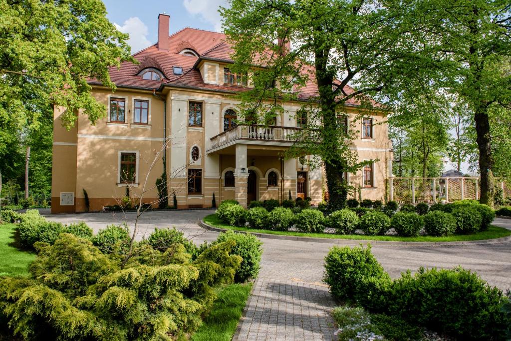 an old house with a garden in front of it at Pałac Ogrodowa in Tarnowskie Góry