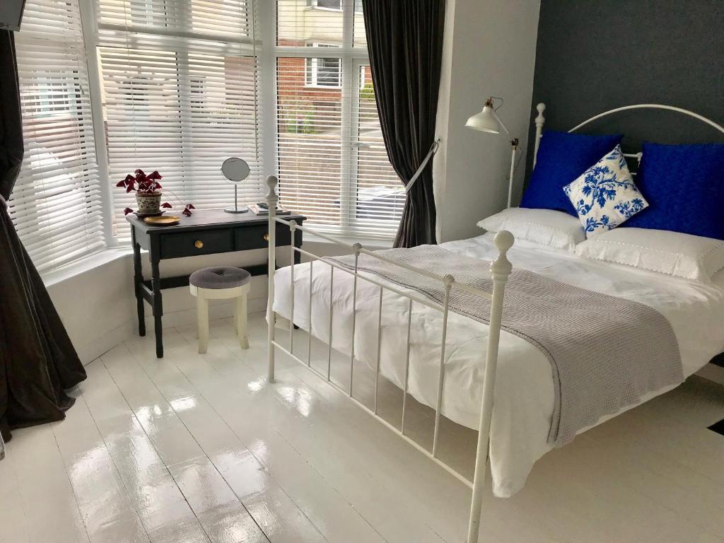 um quarto com uma cama, uma secretária e uma janela em Coverdale em Lyme Regis