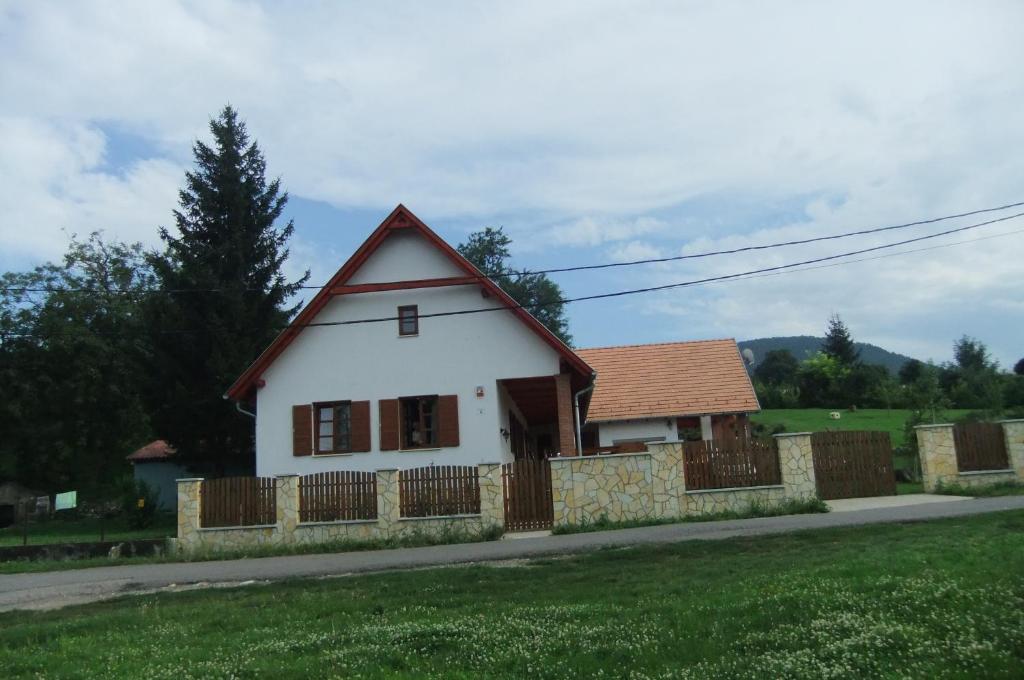 una pequeña casa blanca con una valla en un patio en Galambos Pincészet, en Abaújszántó