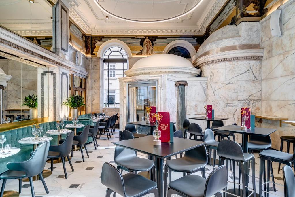 ein Restaurant mit Tischen und Stühlen in einem Gebäude in der Unterkunft Apex Temple Court Hotel in London