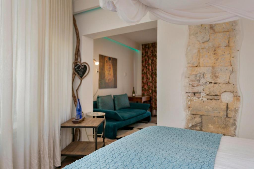 een slaapkamer met een blauw bed en een groene bank bij Het Vakwerkhuis in Valkenburg