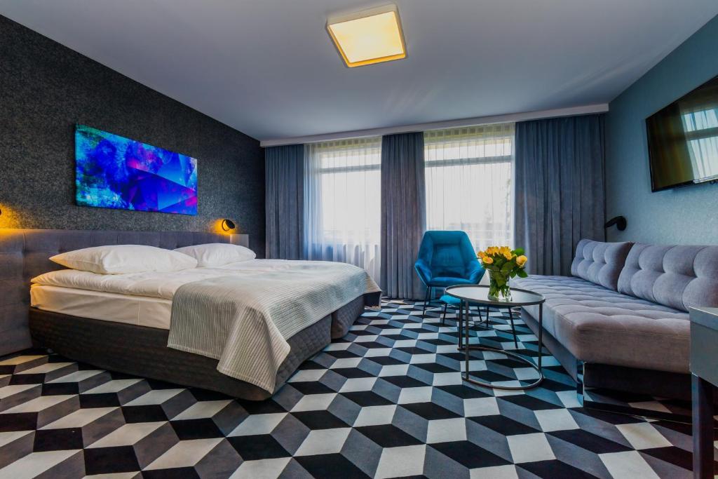 クラクフにあるホテル ヴィスピアンスキのベッドとソファ付きのホテルルーム