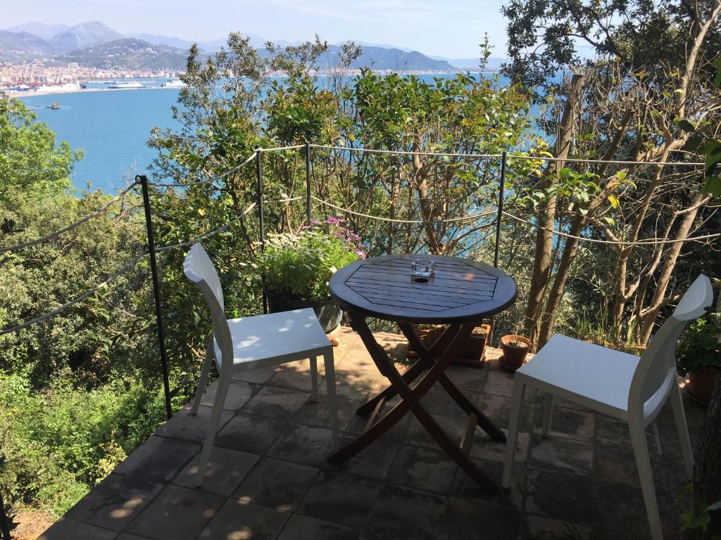 a table and chairs on a patio with a view of the water at Ruderi in Cetara