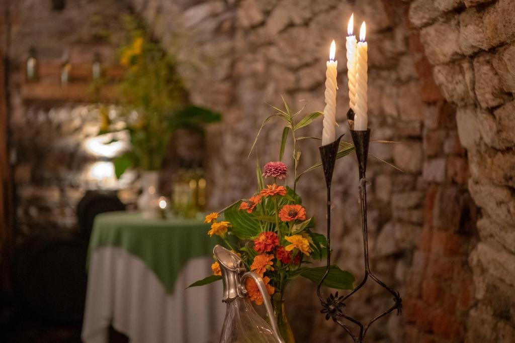 a vase with flowers and candles on a table at Laubgassl in Mörbisch am See