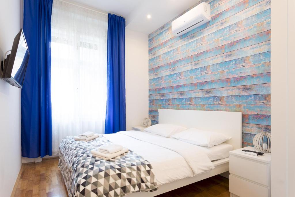 Un dormitorio con una pared de ladrillo y una cama en City Center Apartments, en Zagreb