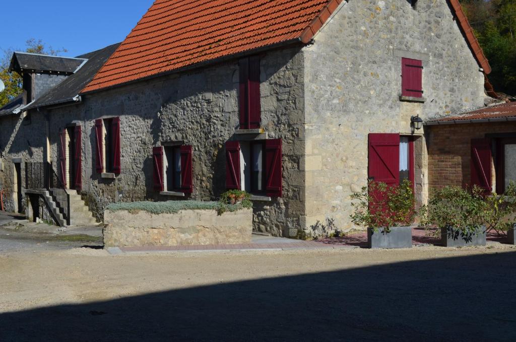 a stone house with red windows and a red roof at Maison indépendante à la campagne in Courcelles-sur-Vesle