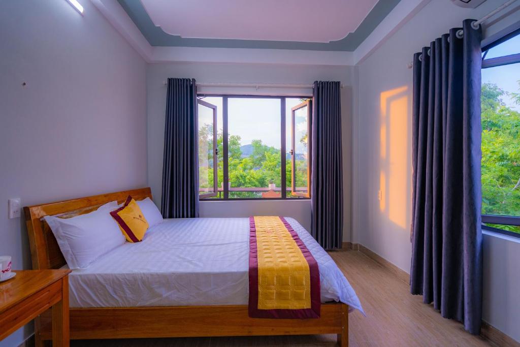a bedroom with a bed and a large window at Fami Homestay in Phong Nha