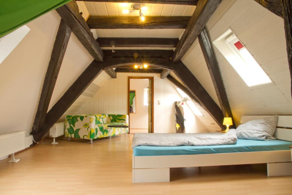 Habitación en el ático con cama y sofá en Ferienwohnung Fritz Walter, en Kreuzwertheim