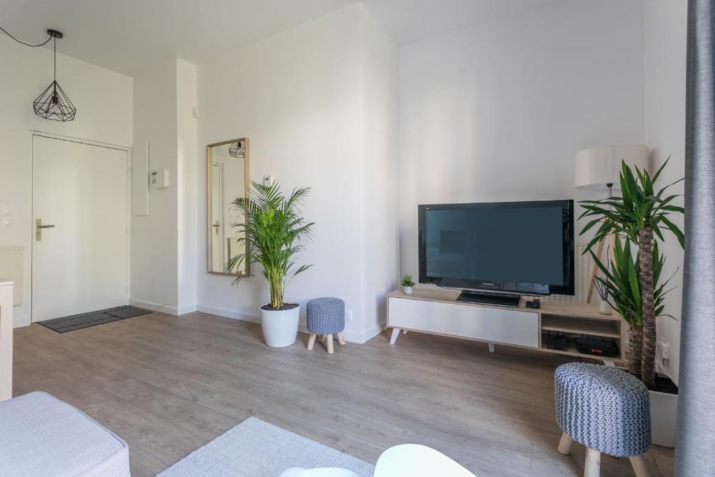 a living room with a flat screen tv and plants at Nice Apartment Garden - 5 min DISNEYLAND Paris - Val d&#39;Europe Center in Chessy