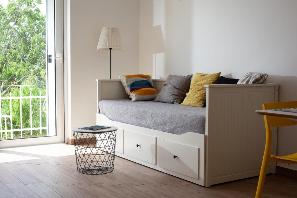 1 cama con almohadas en una habitación con ventana en Apartments Coast 27, en Podgora