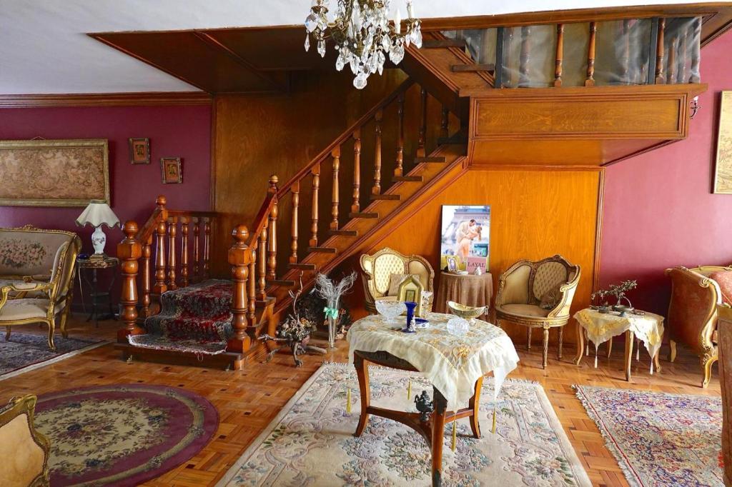 ein Wohnzimmer mit einer Treppe mit einem Tisch und Stühlen in der Unterkunft Elites 1 in Alexandria