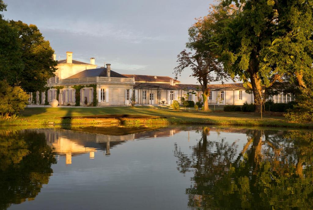 a large house with a pond in front of it at CHASSE-SPLEEN Les Chambres in Moulis-en-Médoc