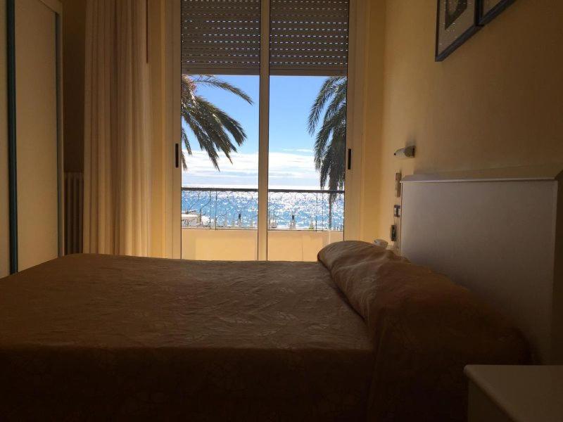 una camera con un letto e una grande finestra di Hotel Solemare ad Albenga