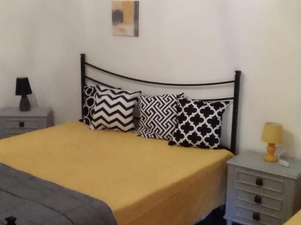 um quarto com uma cama com almofadas em Casa Petros em Marsala