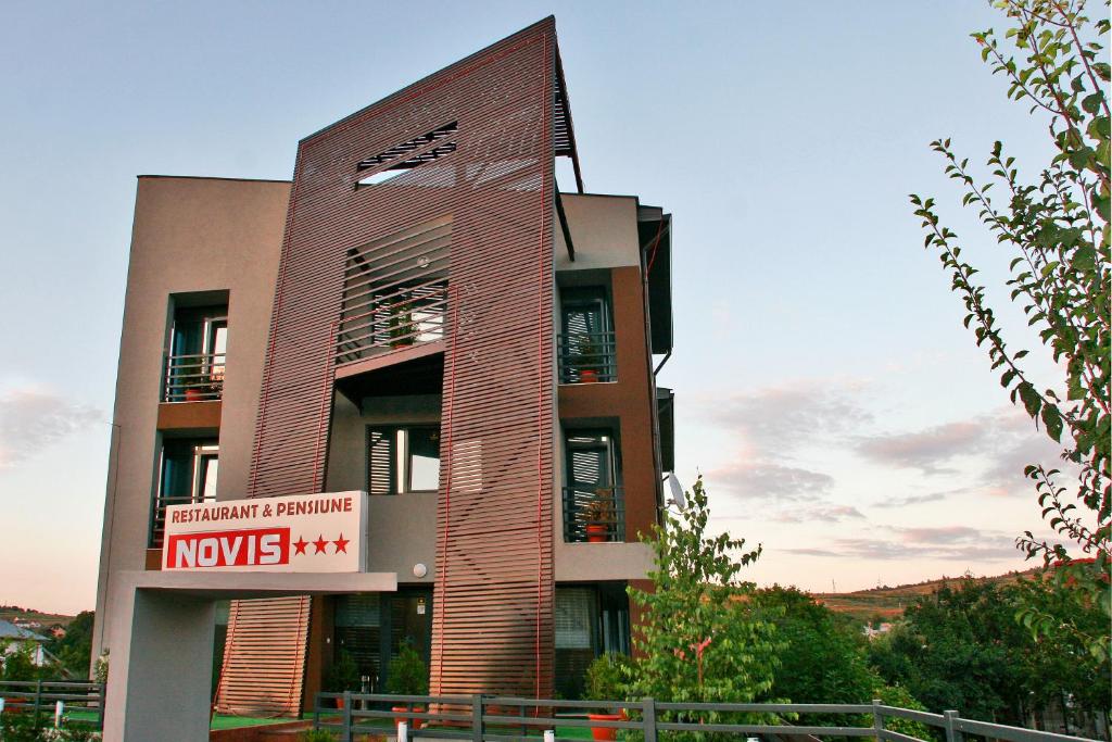 a building with a sign on the side of it at Pensiunea Novis in Iaşi