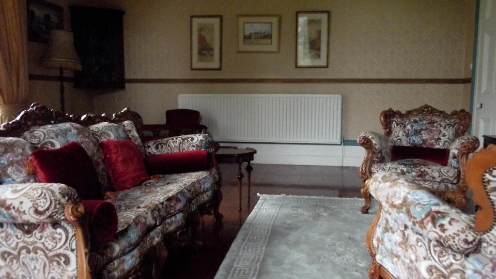 a living room with two couches and a radiator at Gardenvale Manor House B&B in Stranocum