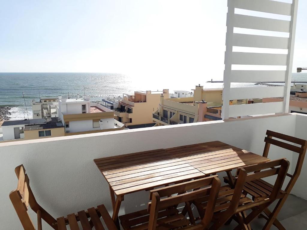 a table and chairs on a balcony with a view of the ocean at Atlantico 8- Vista Mar, Ar-Condicionado, 80mt Praia, Wifi in Quarteira
