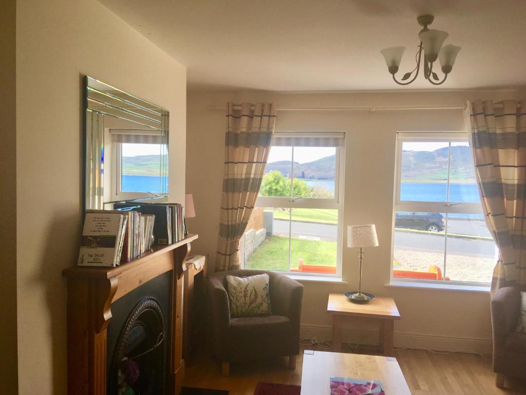 a living room with a chair and two windows at Foxglove House in Valentia Island