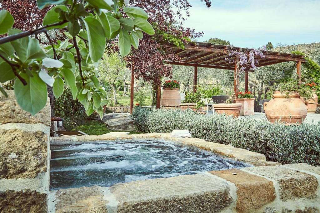 a pool of water surrounded by a stone wall at B&B Daria Monticchiello in Monticchiello