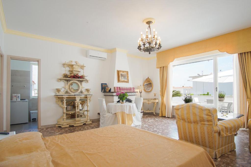a living room with a table and a clock on the wall at Appartamento in villa ad Ischia in Ischia