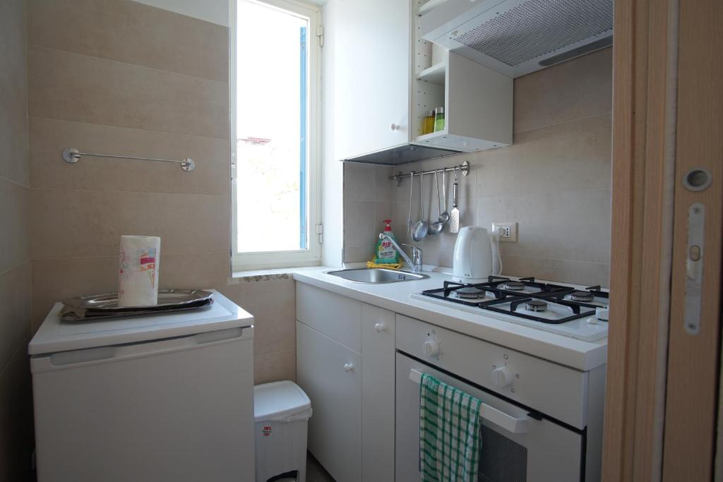 a small kitchen with a stove and a sink at Appartamento in villa ad Ischia in Ischia