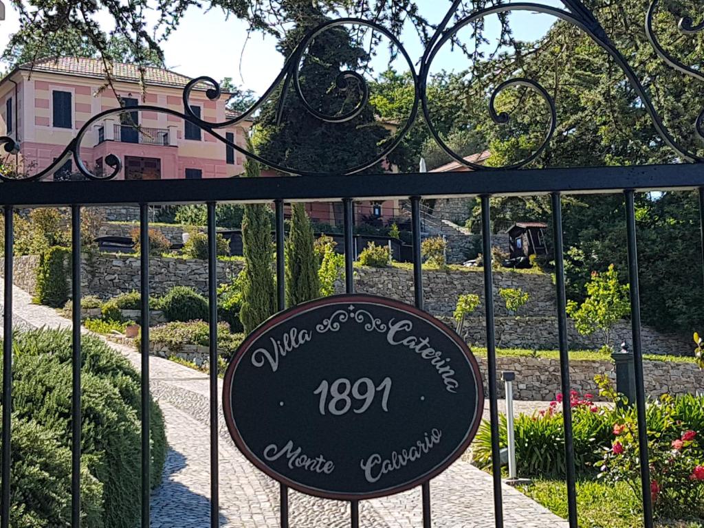 um sinal num portão em frente a um jardim em Villa Caterina em Imperia
