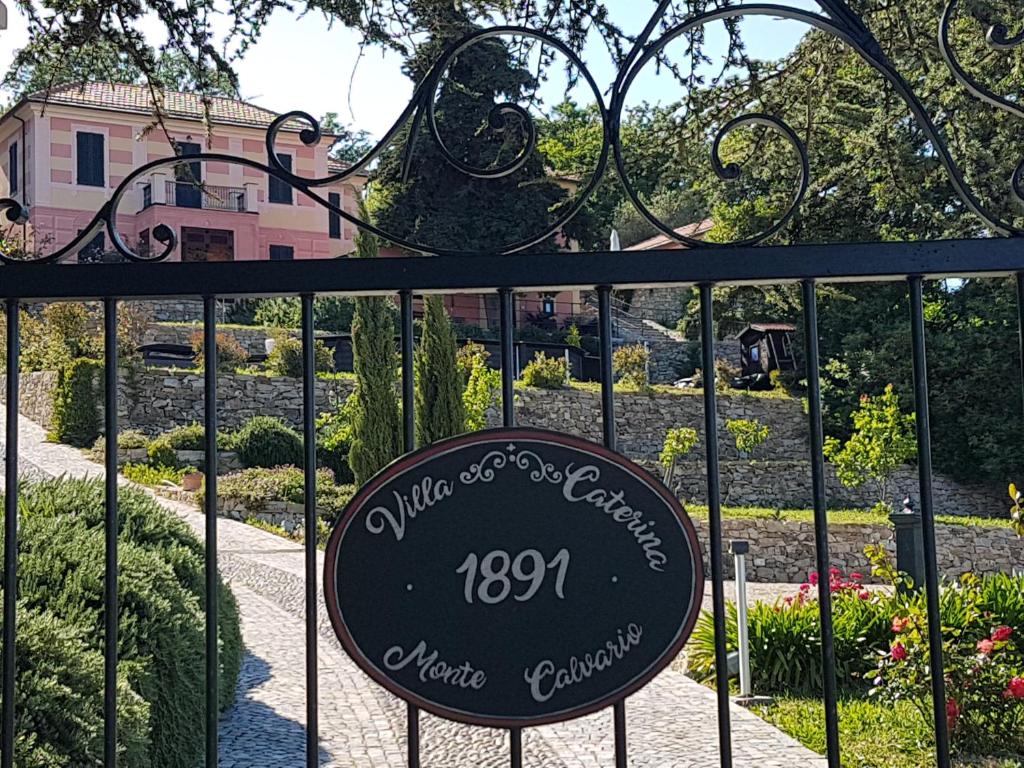 un cartel en una puerta frente a un jardín en Villa Caterina, en Imperia